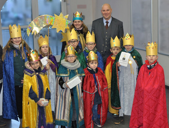 Zu sehen ist Bürgermeister Lukrafka mit einer Gruppe von elf Sternsingern im Velberter Rathaus.