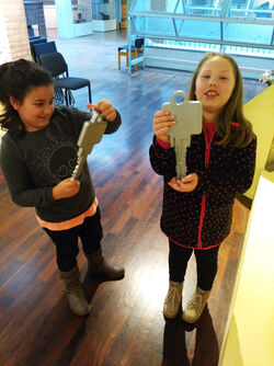 Zu sehen sind zwei Schülerinnen in den Austellungsräumen des Schloss- und Beschlägemuseums. Beide Mädchen halten einen großen Schlüssel in den Händen.